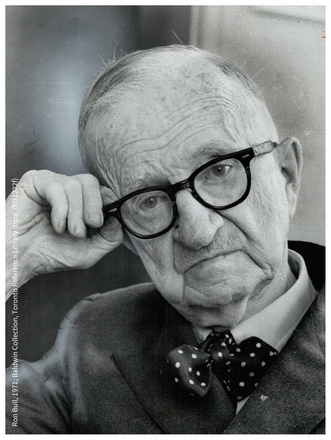 Black and white photograph of an older man in a polka-dot bowtie and black-rimmed glasses.