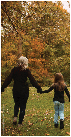 Photo of author and her daughter, holding hands and walking away from photographer on a fall day outdoors.