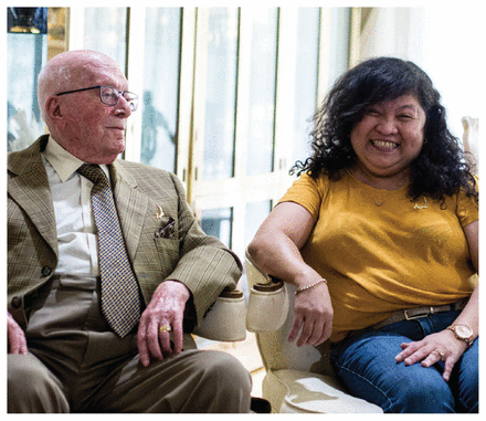 Photo of caregiver Marizel Reyes Evangelista sitting with her 97-year-old employer Sam Meister.